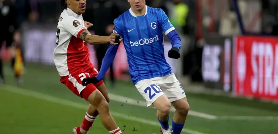 Jugador de Genk driblando mientras es marcado por oponente