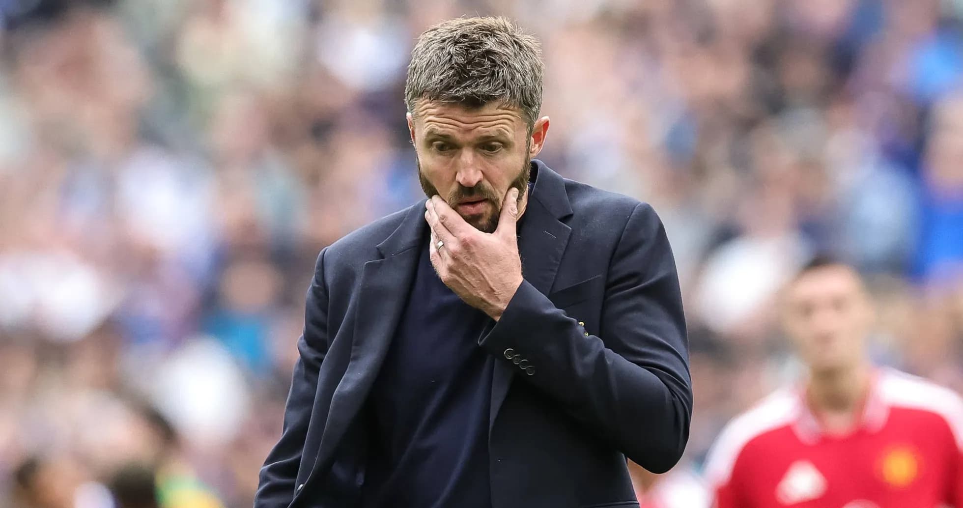 Entrenador pensativo en el banquillo durante el partido