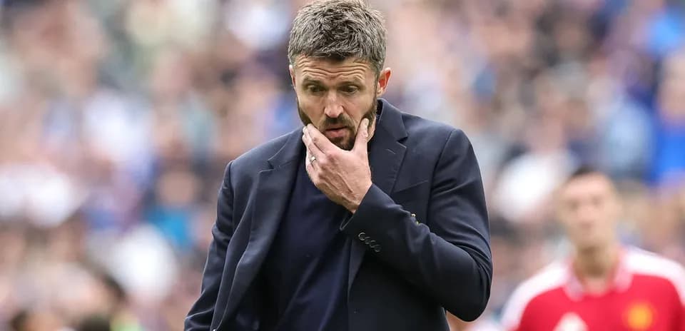 Entrenador pensativo en el banquillo durante el partido