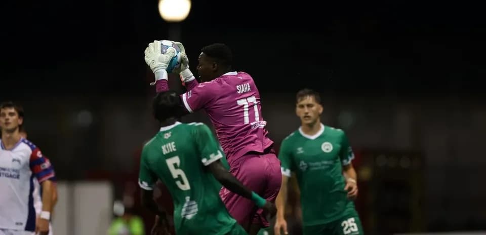Portero atrapando el balón durante el partido