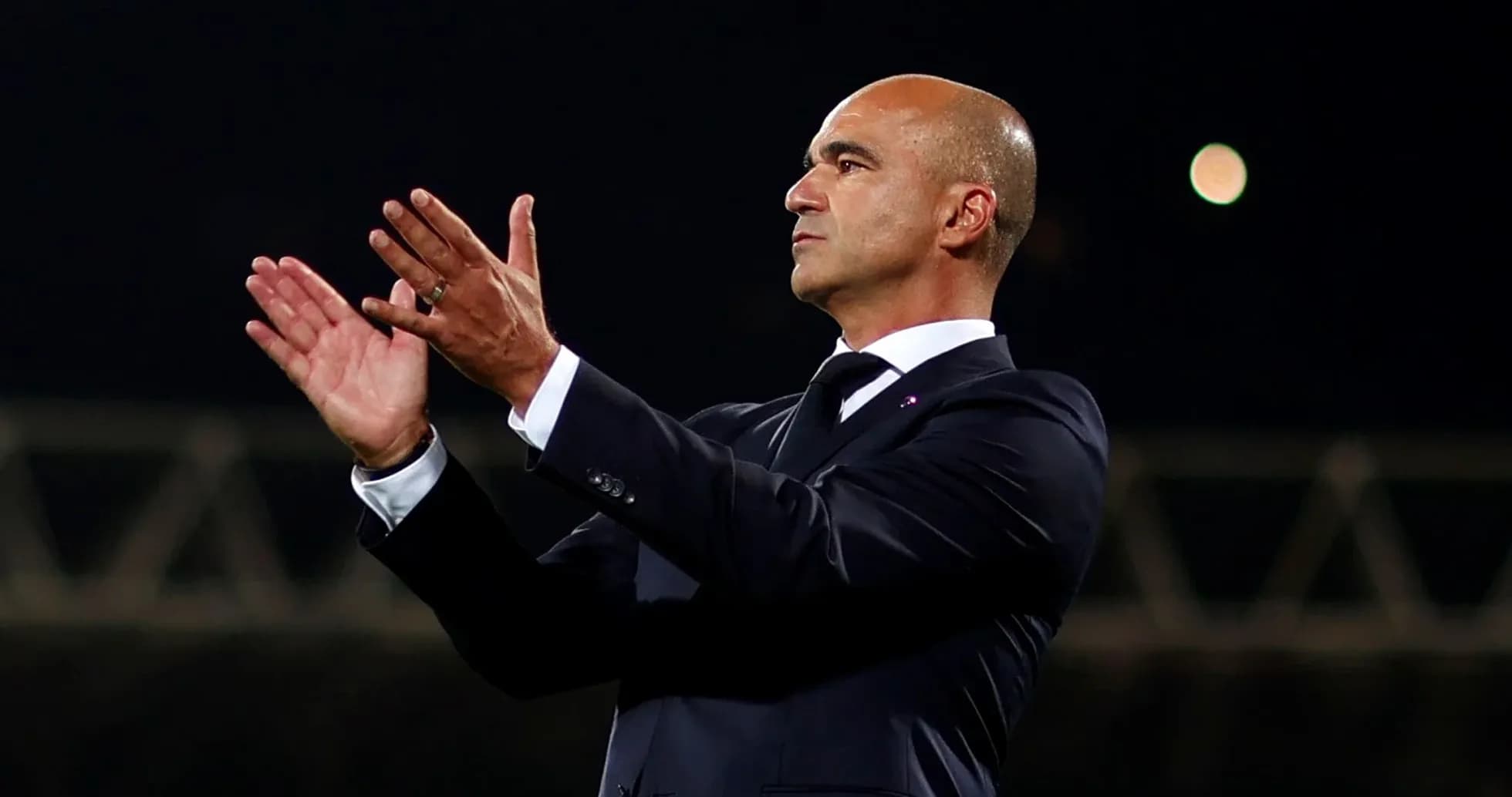 Entrenador aplaudiendo desde la banda del campo