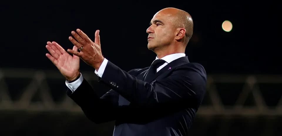 Entrenador aplaudiendo desde la banda del campo
