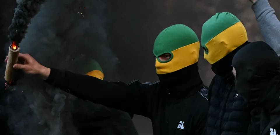 Grupo de personas con máscaras encendiendo una bengala