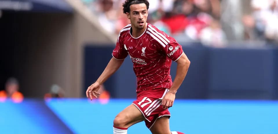 Jugador de Liverpool corriendo con el balón en el campo