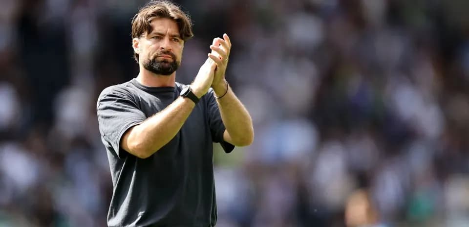Entrenador aplaudiendo en el campo durante el partido