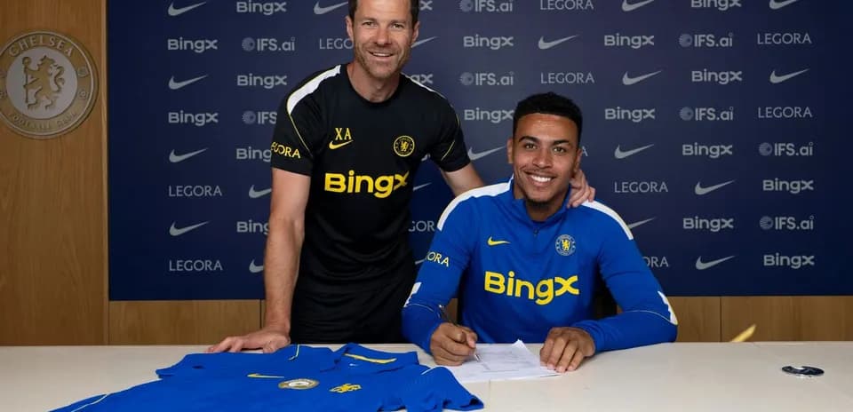 Jugador firmando contrato con el entrenador en Chelsea