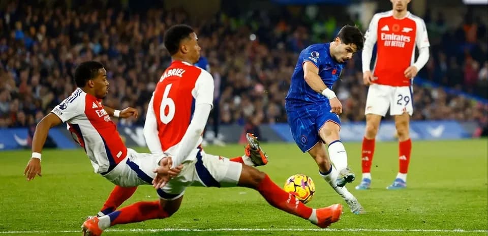 Jugador de Chelsea disparando entre defensores de Arsenal