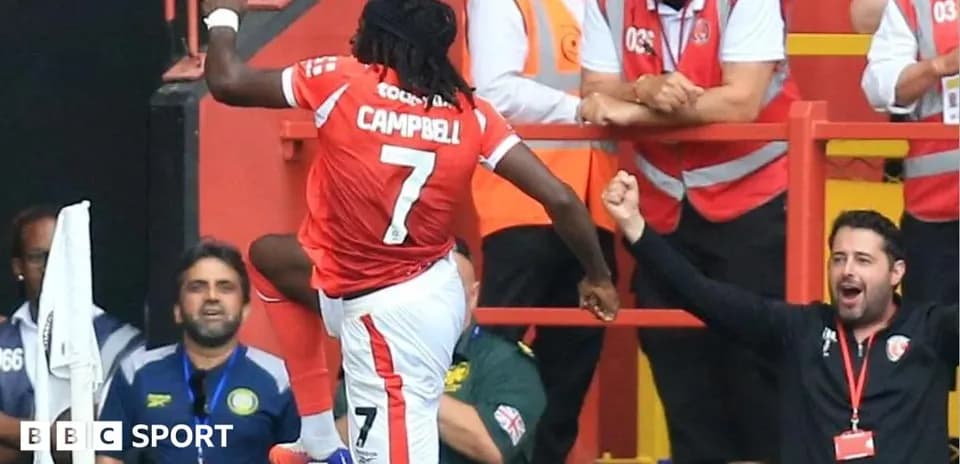 Jugador celebrando un gol con aficionados en el fondo