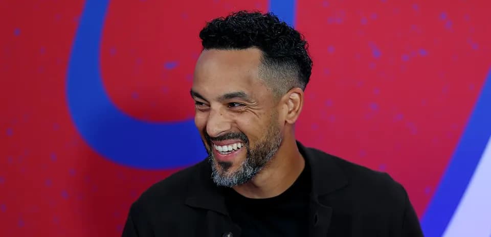 Hombre sonriendo durante una conferencia de prensa