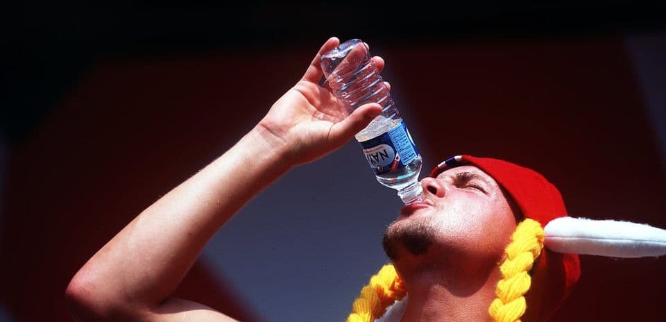 Hombre bebiendo agua de botella durante evento