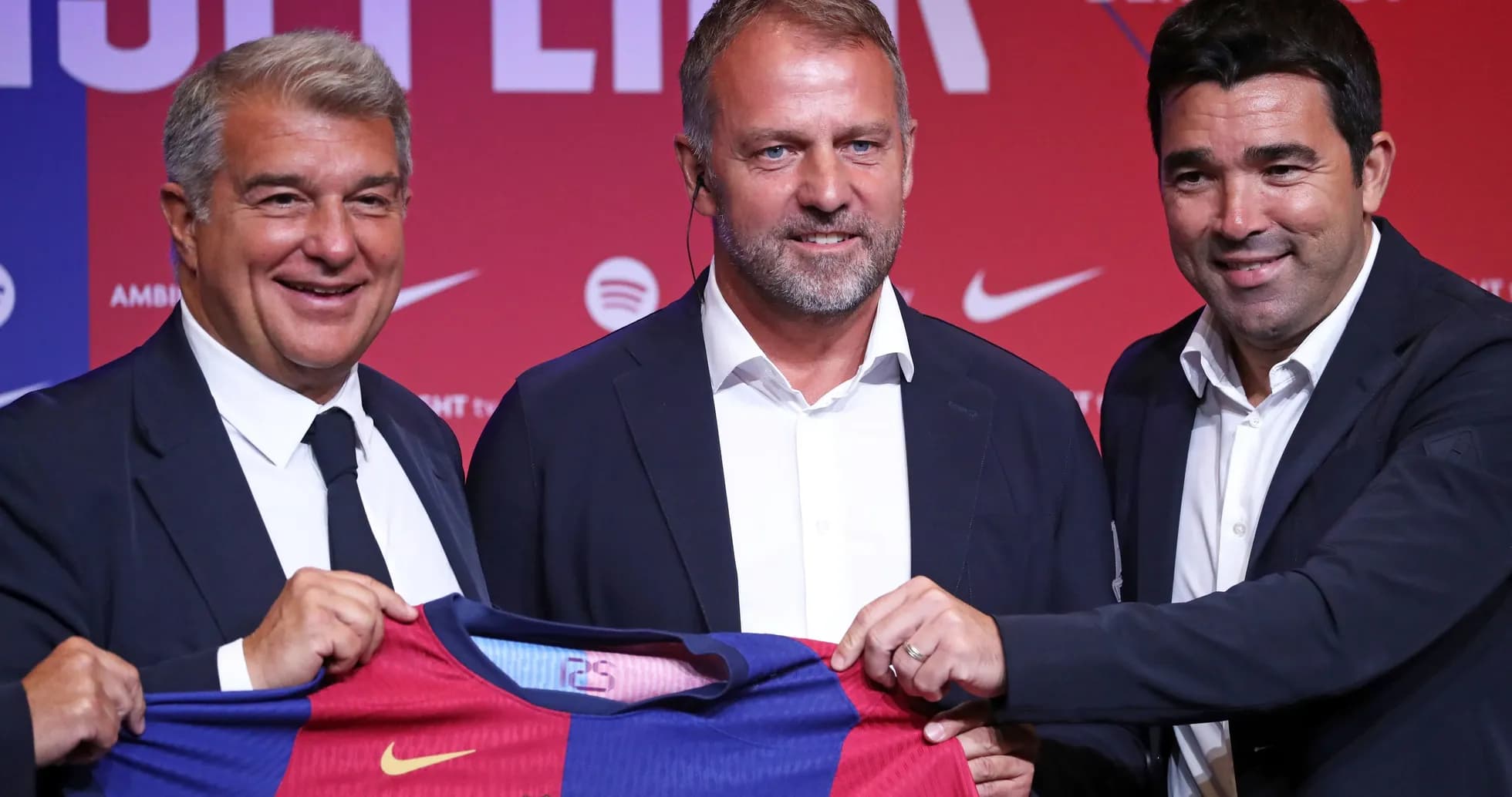 Tres personas sosteniendo camiseta del FC Barcelona en evento