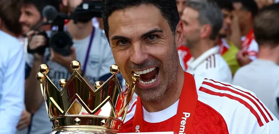 Entrenador sosteniendo trofeo de la Premier League