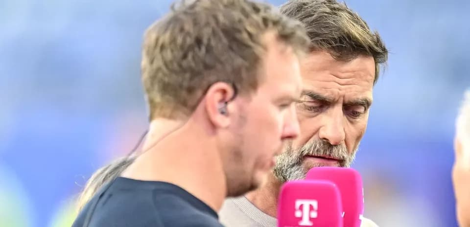 Dos hombres hablando en un evento deportivo