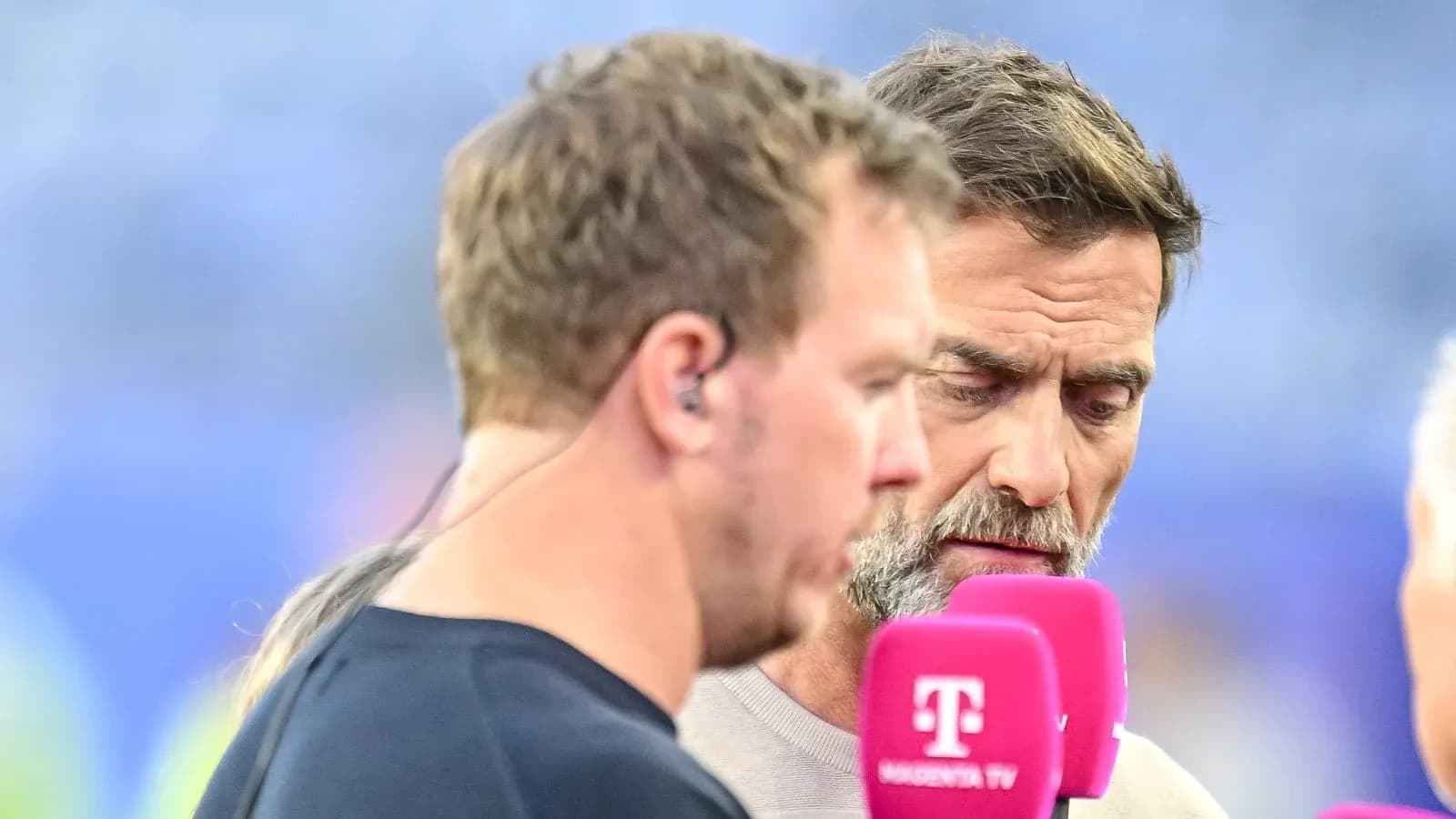 Dos hombres hablando en un evento deportivo