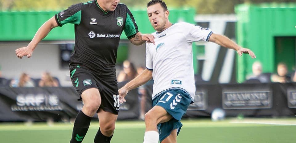 Dos jugadores compitiendo por el balón en el partido