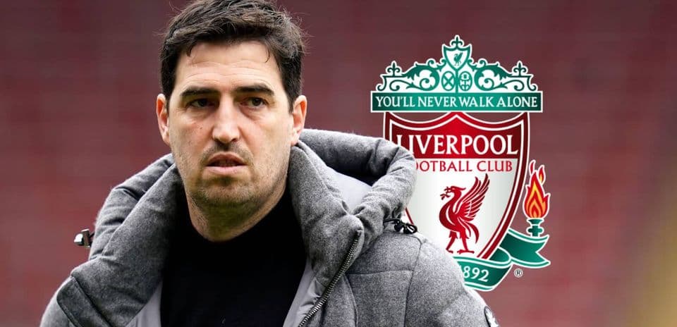 Entrenador de Liverpool frente al escudo del club