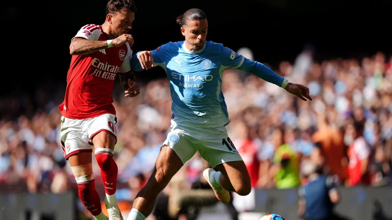 Jugadores de Arsenal y Manchester City disputando el balón