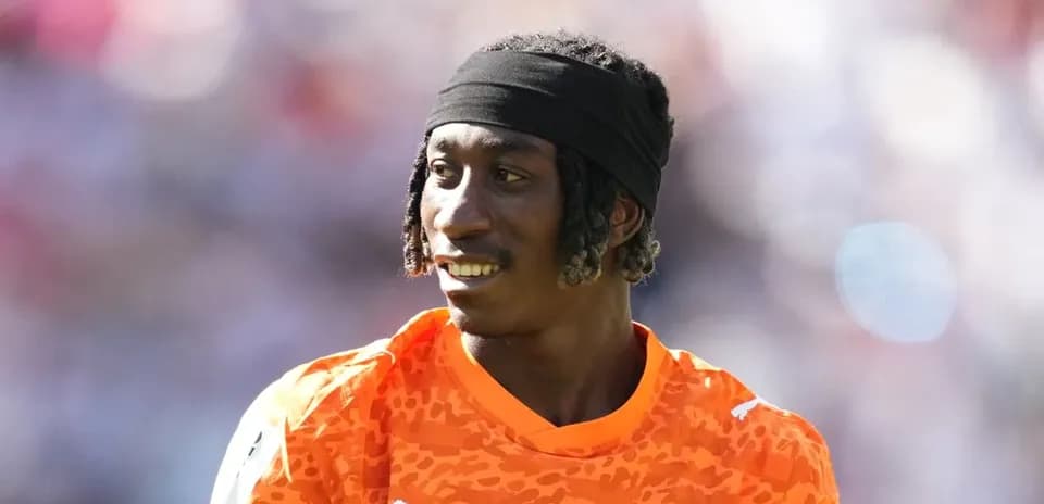Portero con camiseta naranja en el campo de juego