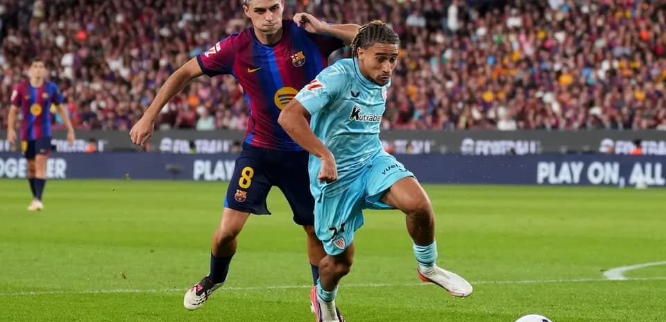 Jugador del Barcelona persiguiendo a oponente con balón