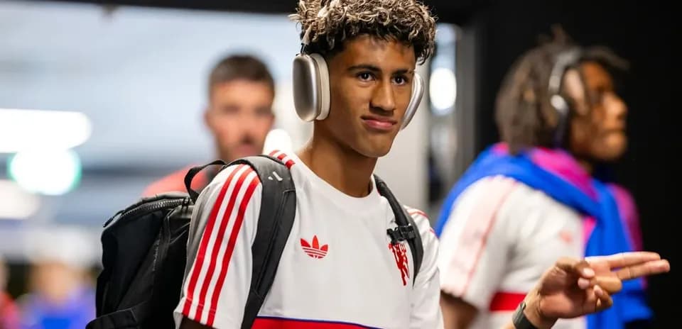 Jugador entrando con auriculares y mochila en vestuario