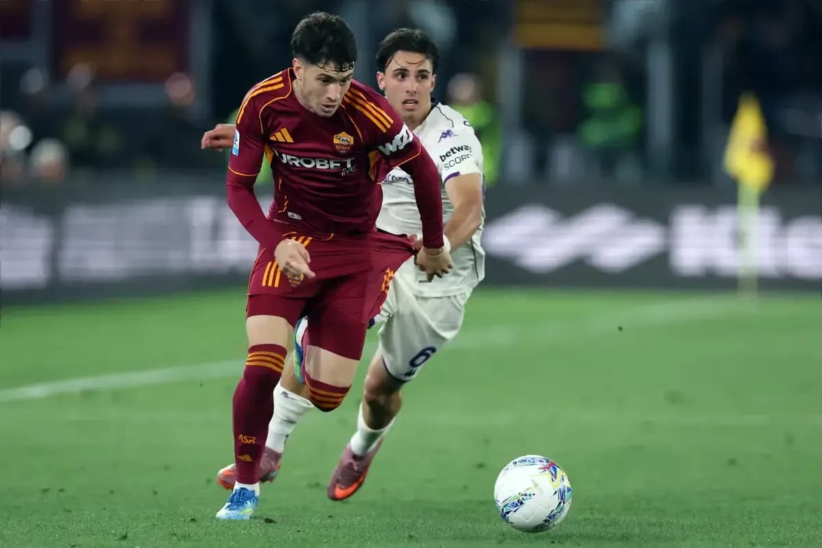 Jugador de la Roma driblando mientras es seguido por oponente