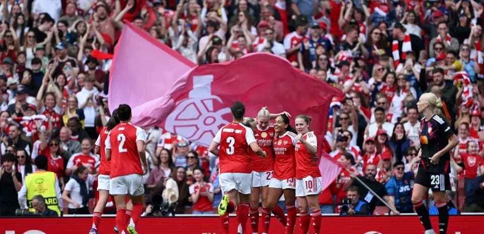 Jugadoras de Arsenal celebrando un gol con afición animada