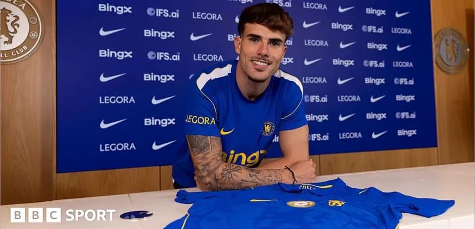 Jugador posando con camiseta de Chelsea en conferencia