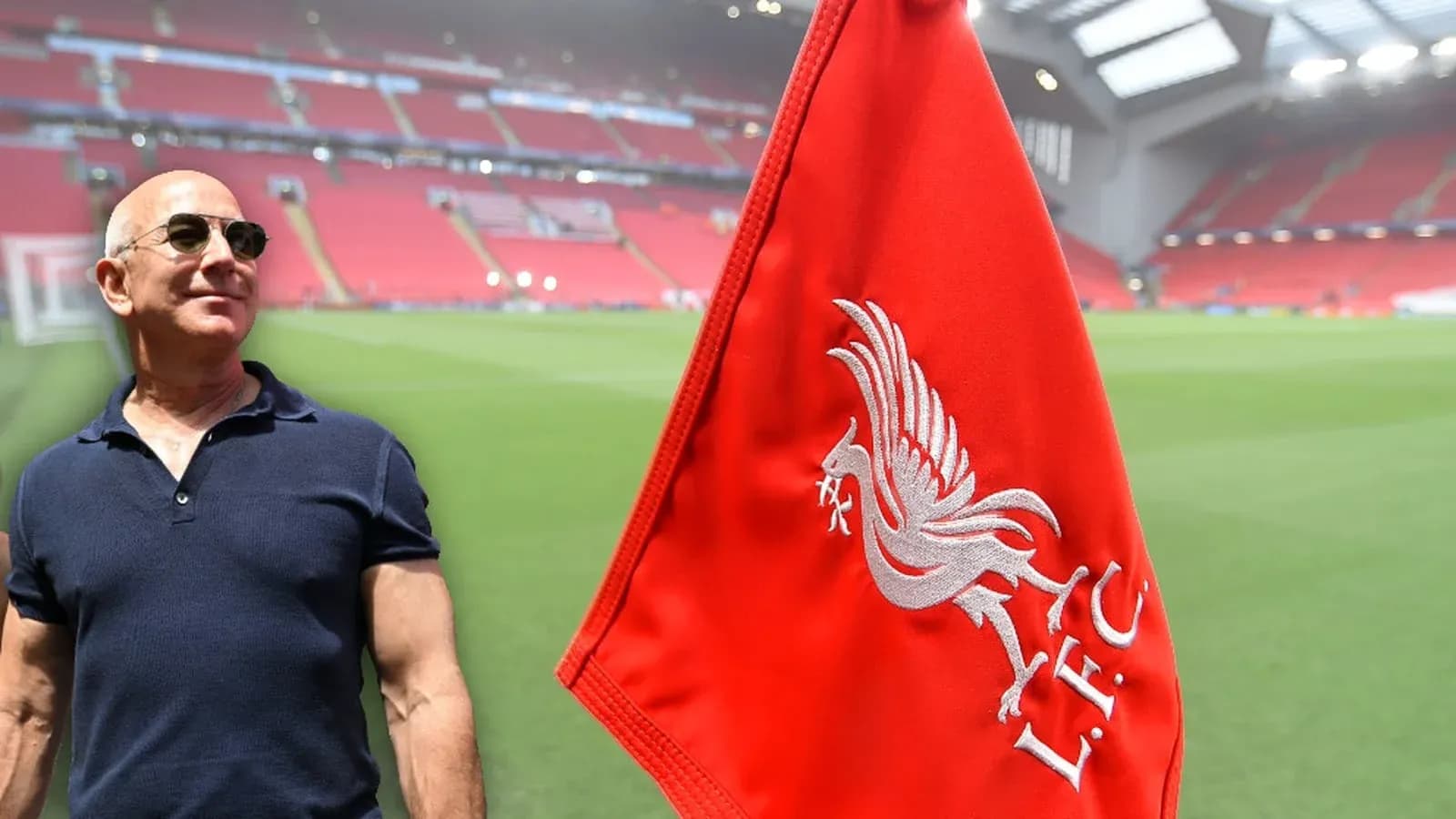Hombre junto a bandera de Liverpool en estadio vacío