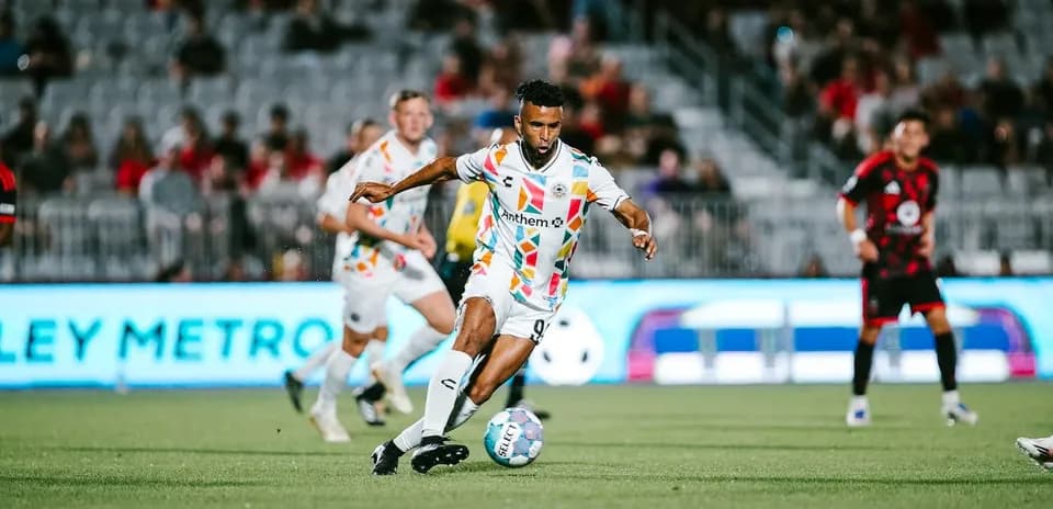 Jugador de Phoenix Rising avanzando con el balón