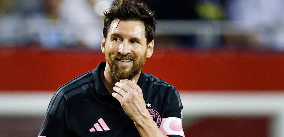 Jugador con camiseta oscura sonriendo en el campo