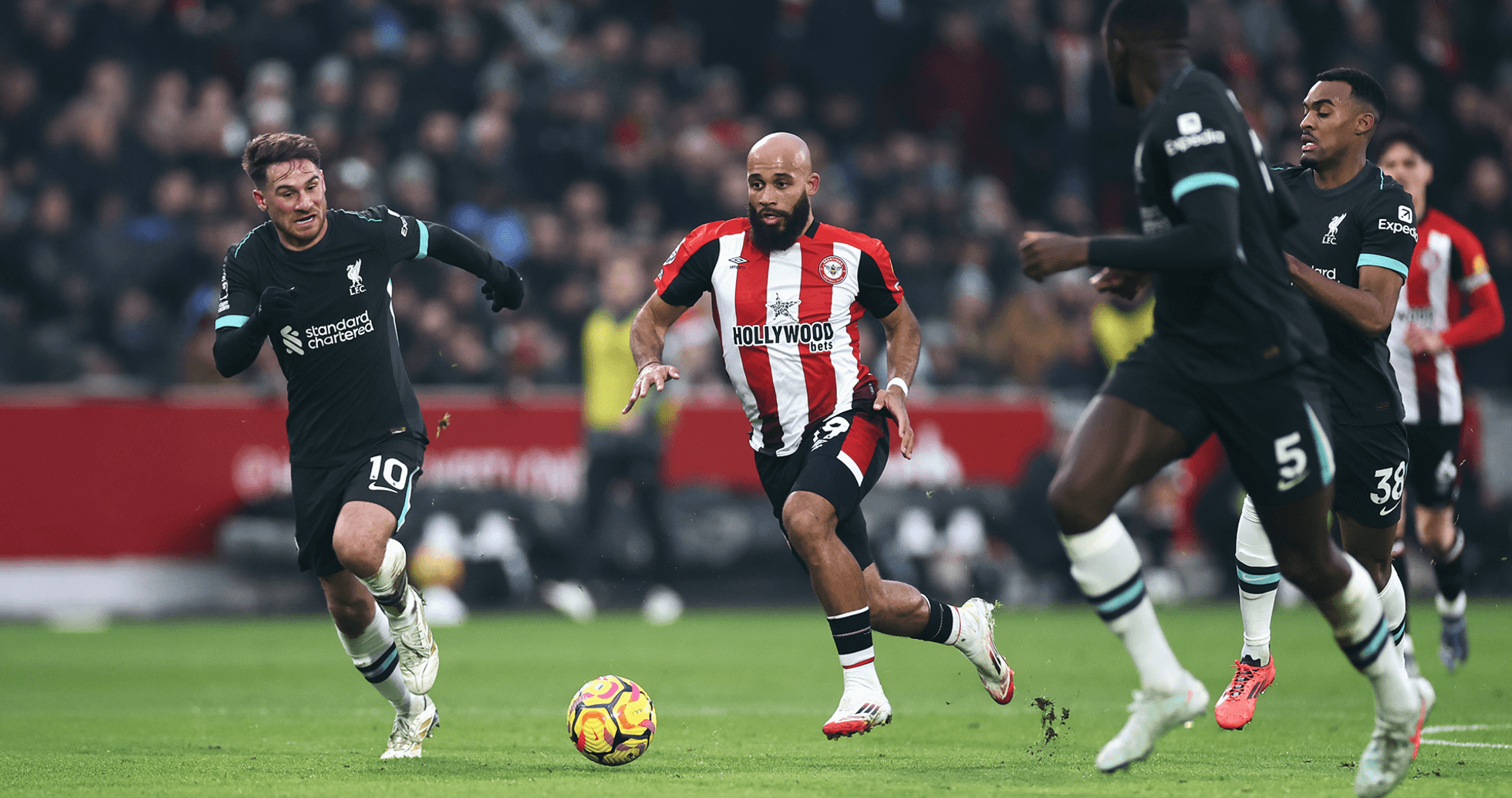 Jugador de Brentford esquivando a los defensores de Liverpool