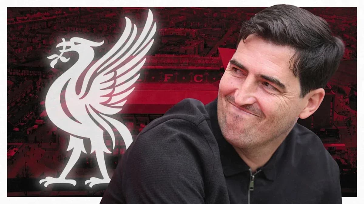 Entrenador sonriente frente al logo de Liverpool