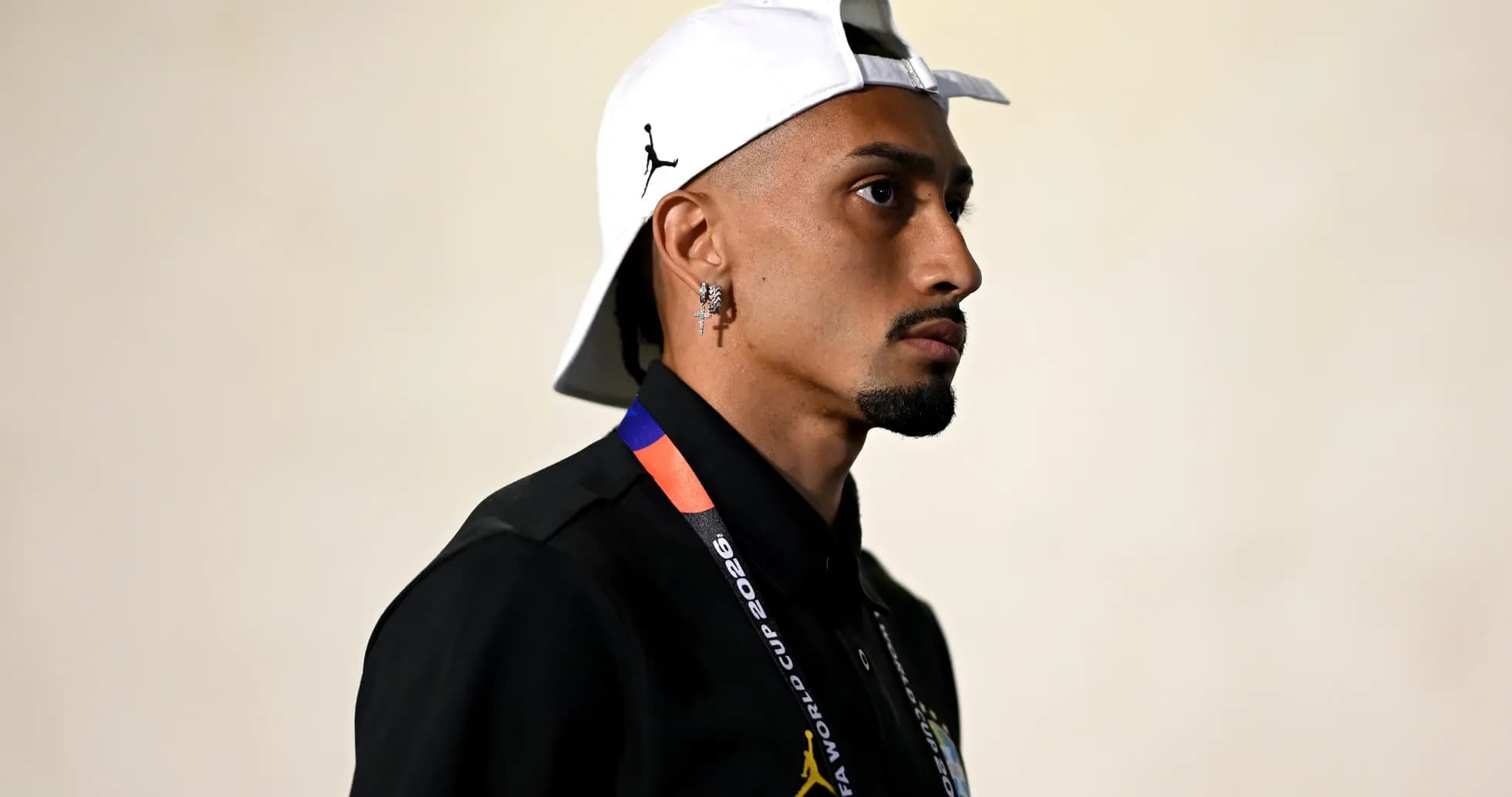 Persona con gorra blanca y collar de FIFA