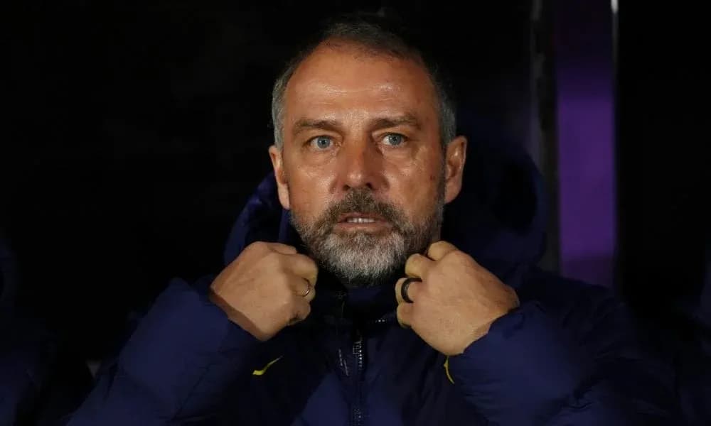 Entrenador ajustando su chaqueta en el banquillo