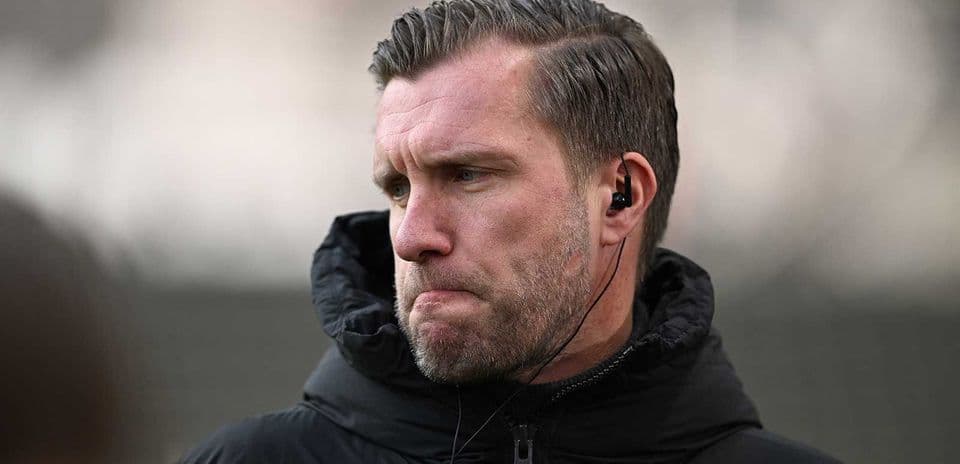 Entrenador con auriculares en la cancha