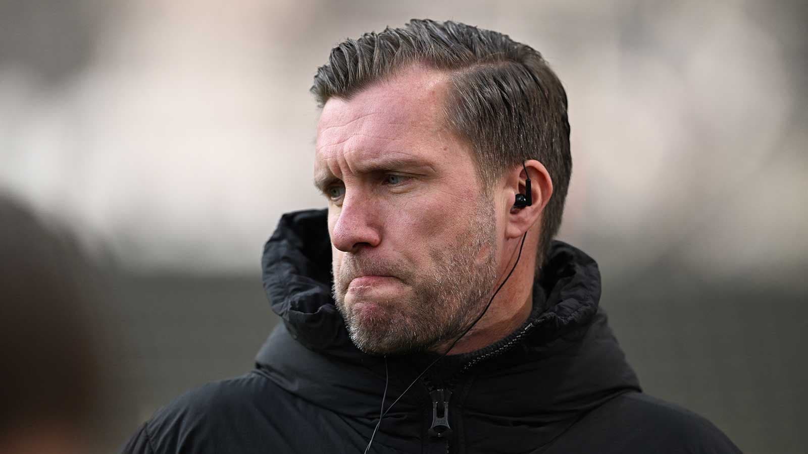 Entrenador con auriculares en la cancha