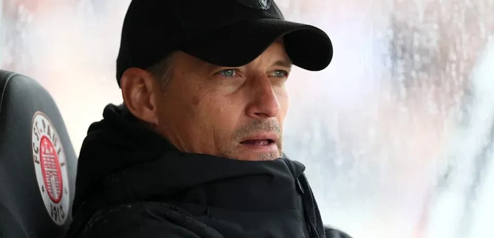 Entrenador observando el partido desde el banquillo