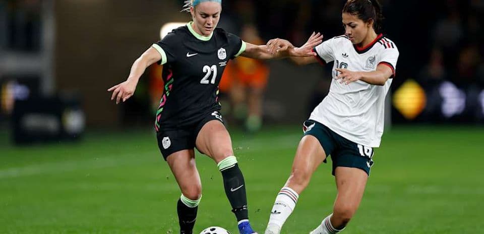 Jugadora de Estados Unidos y México compitiendo por el balón