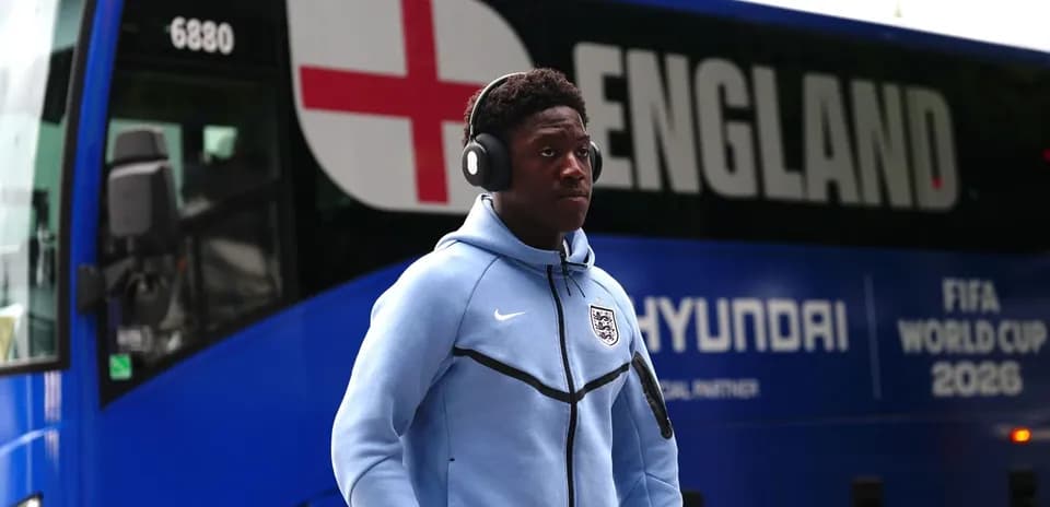 Jugador caminando junto al autobús de Inglaterra