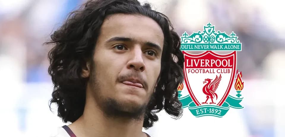 Jugador con cabello rizado frente al logo de Liverpool