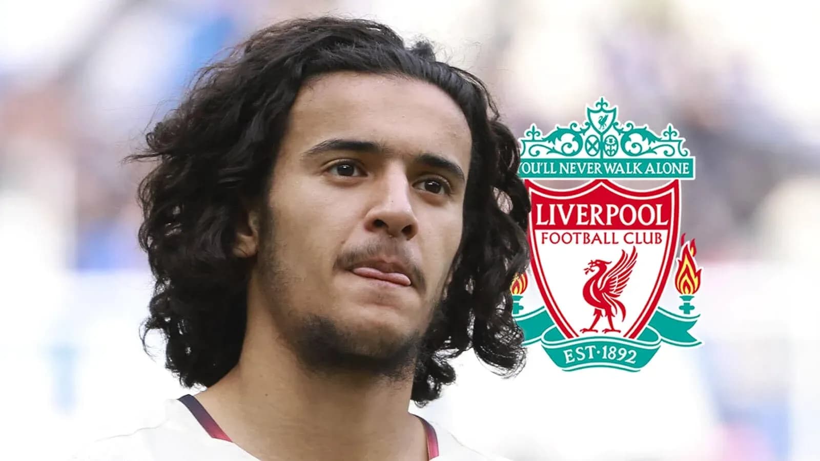 Jugador con cabello rizado frente al logo de Liverpool