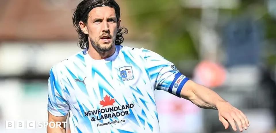 Jugador corriendo en camiseta de fútbol blanca y azul