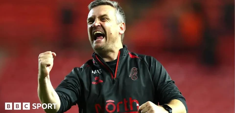 Entrenador celebrando con puños en alto tras victoria
