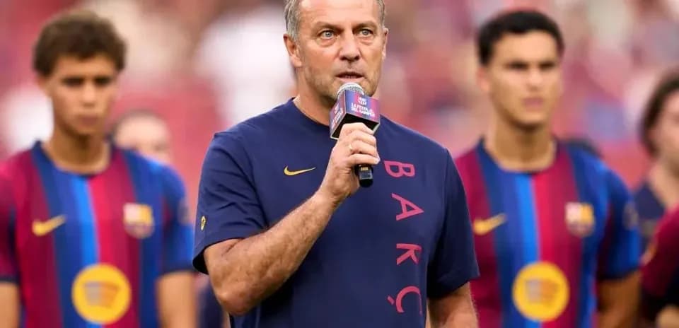 Entrenador hablando en evento con jugadores detrás