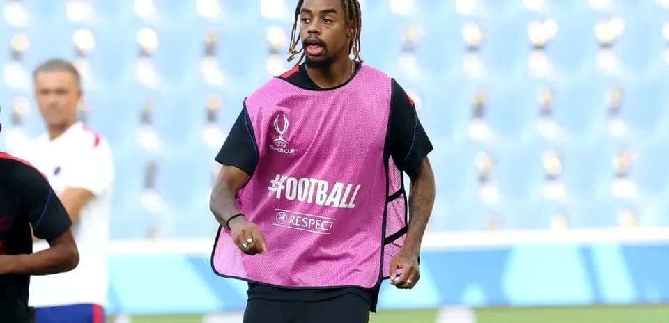 Jugador entrenando con peto rosa en el campo