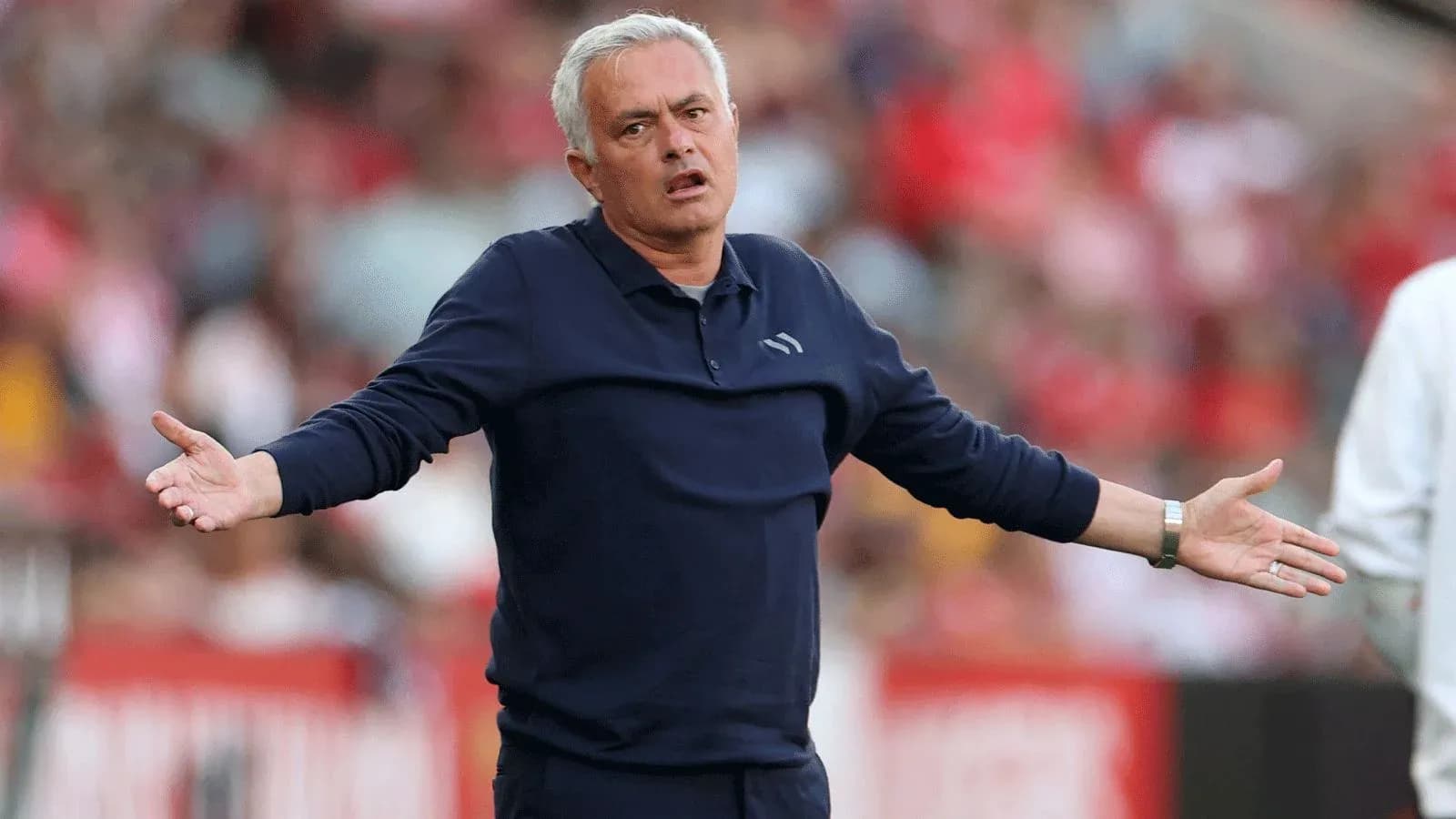 Entrenador gesticulando durante un partido de fútbol