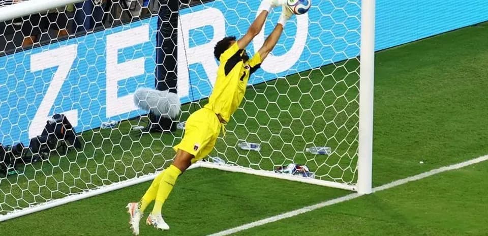 Portero saltando para detener un tiro a gol