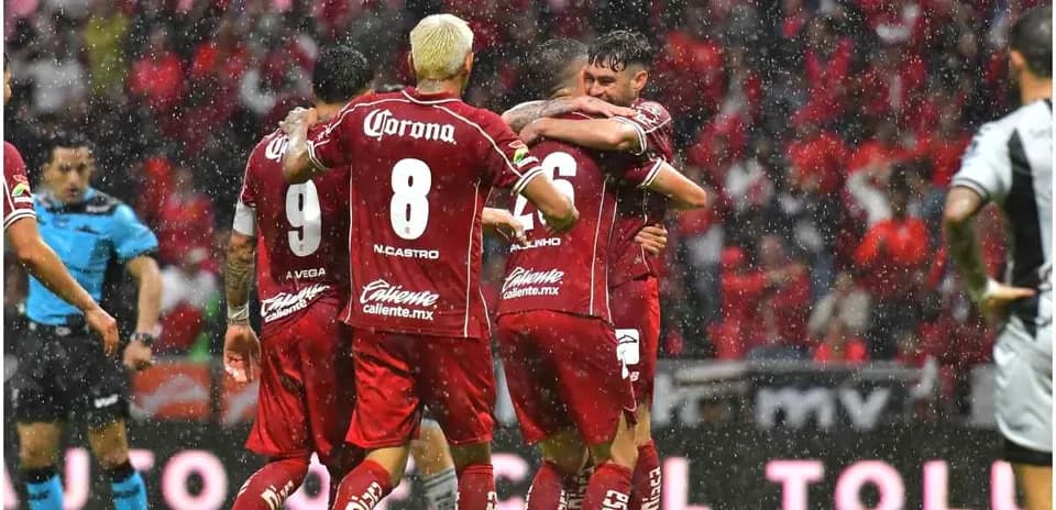 Jugadores de Toluca celebrando un gol bajo la lluvia