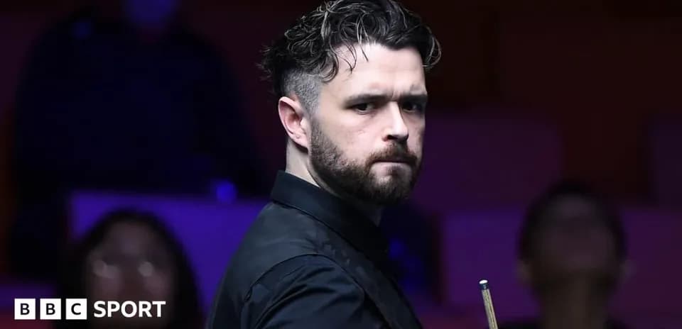 Jugador de snooker sosteniendo un taco en la mesa