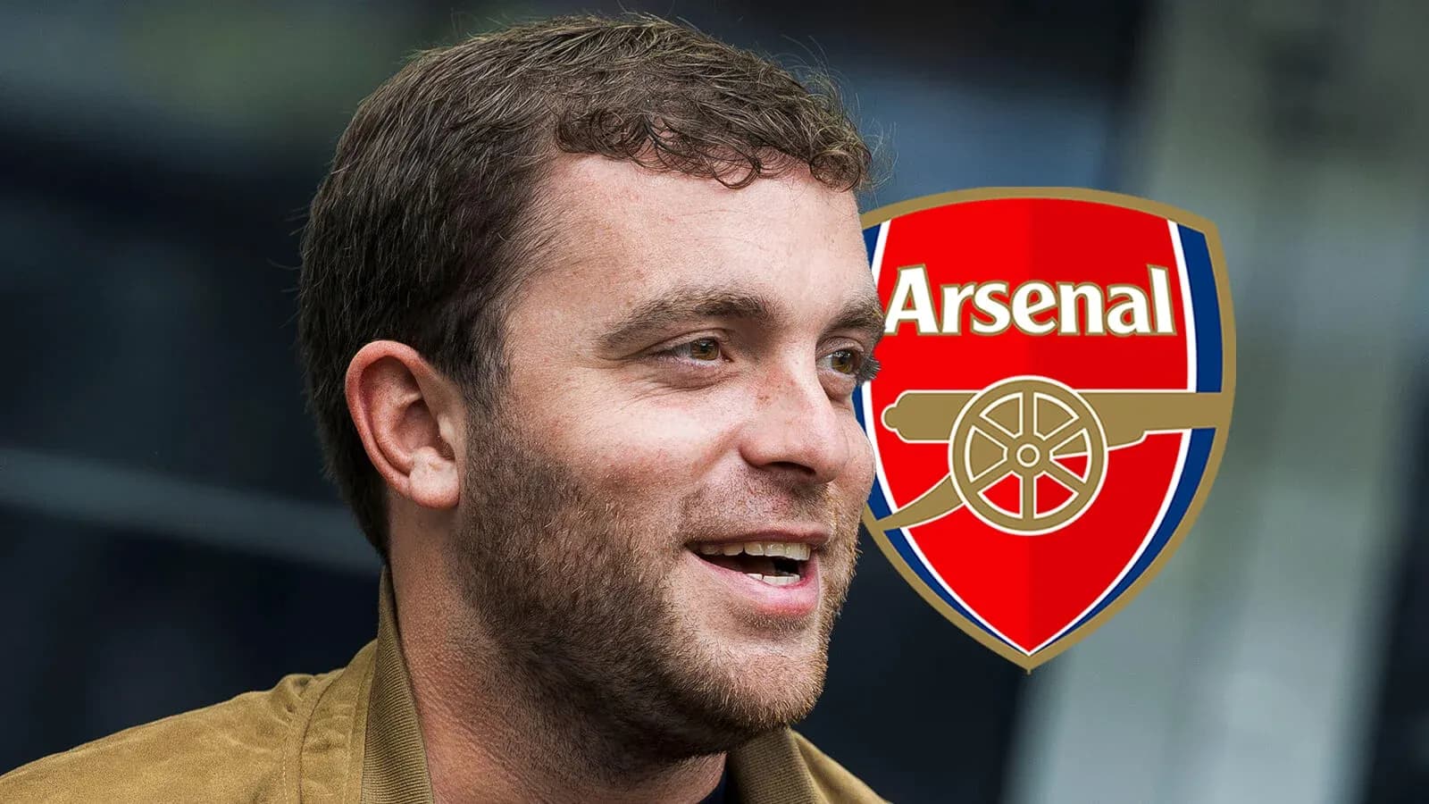 Hombre sonriendo con el escudo de Arsenal detrás